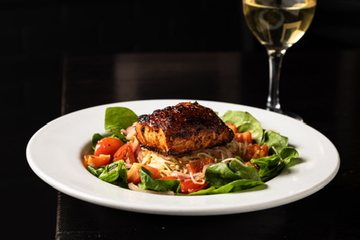 A complete plate of Sugar Spiced Salmon over pasta and spinach