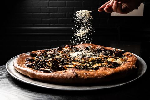 Grated cheese falling onto a freshly baked Sorriso pizza
